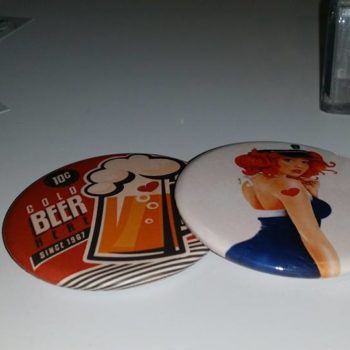 Objet Publicitaire mirroir avec un chope de bière avec un coeur aux couleur rouge, noir et blanc ainsi qu'un pins blanc avec une femme au cheveux orange, une robe bleu et blanche avec une casquette martime et un coeur rouge sur le bras