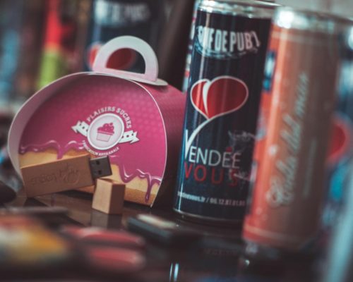Création objet publicitaire aux Sables d'Olonne en Vendée Objet publicitaire avec deux canettes de boisssons énergisantes avec le logo coeur de Vendée Vous ainsi qu'une boîte et une clée USB personnalisés